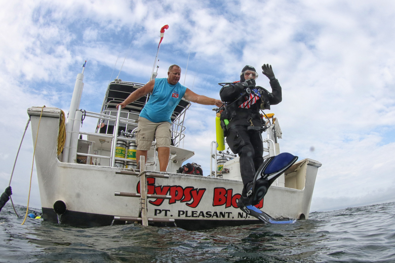 A scuba diver jumping off the dive boat Gypsy Blood off the New Jersey coast